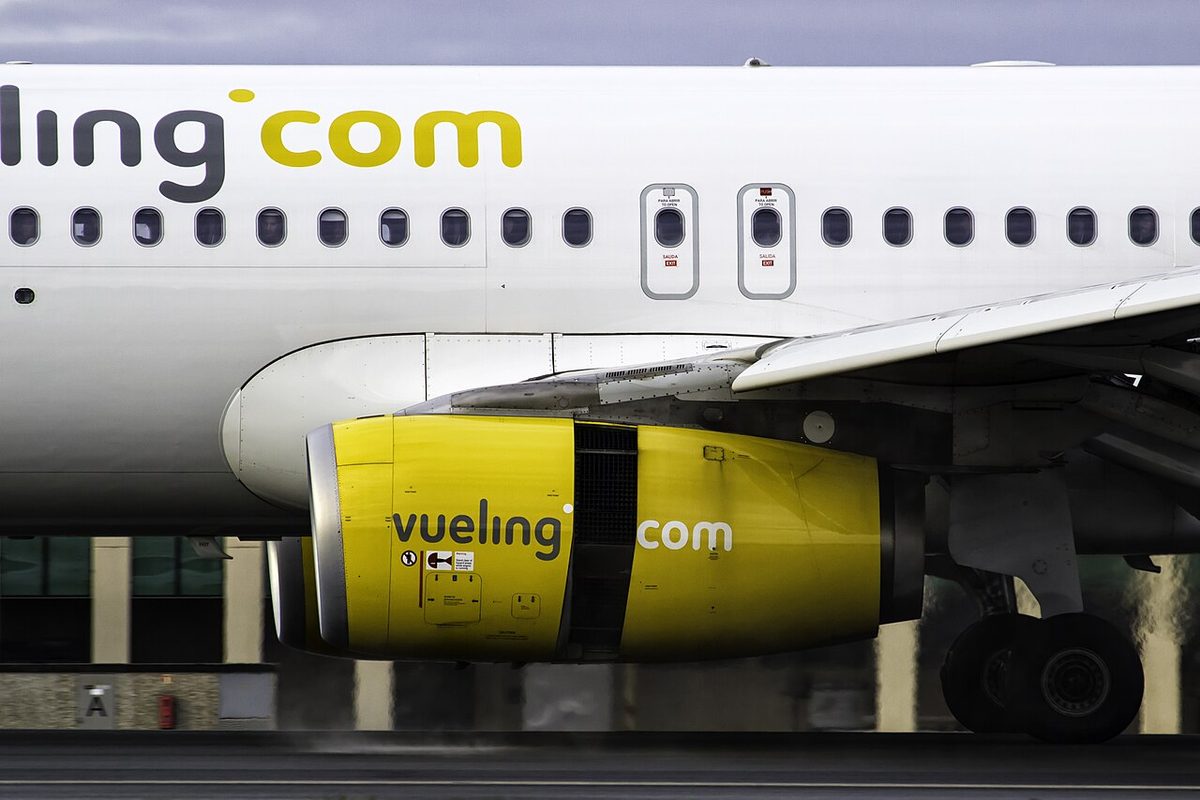 The yellow engine nacelle of an Airbus A320 on the ground, with a dark band of open vanes across the middle of the nacelle.