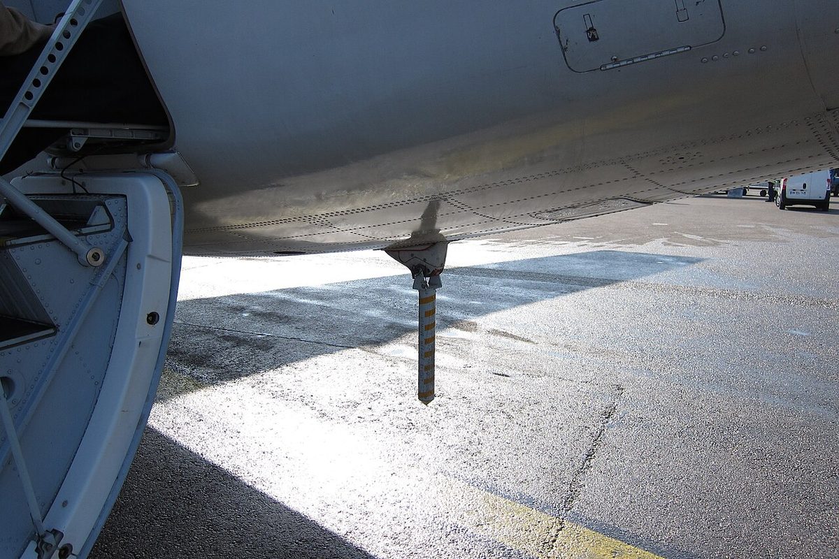A support stand placed under the rear fuselage of a parked aircraft.