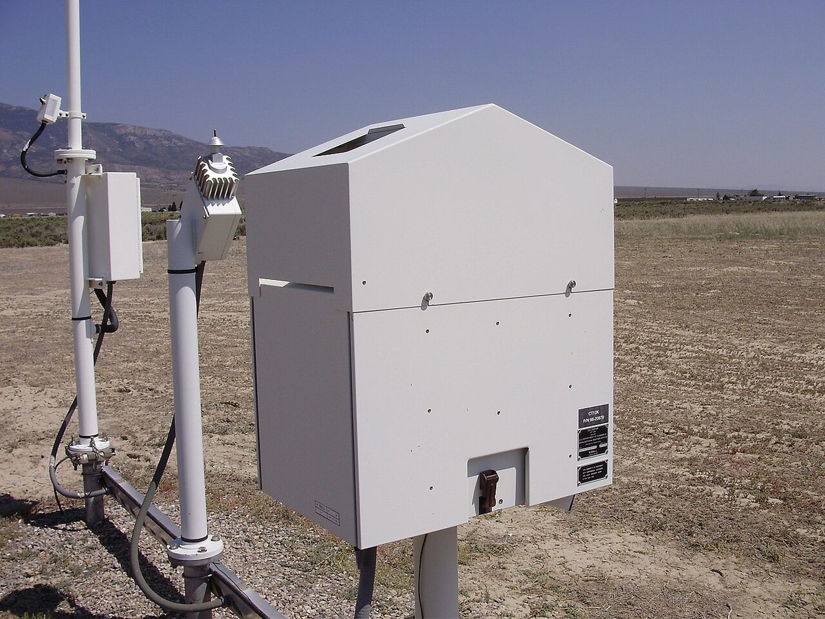 A weather instrument housing with a window on its top, pointing straight up at the sky.