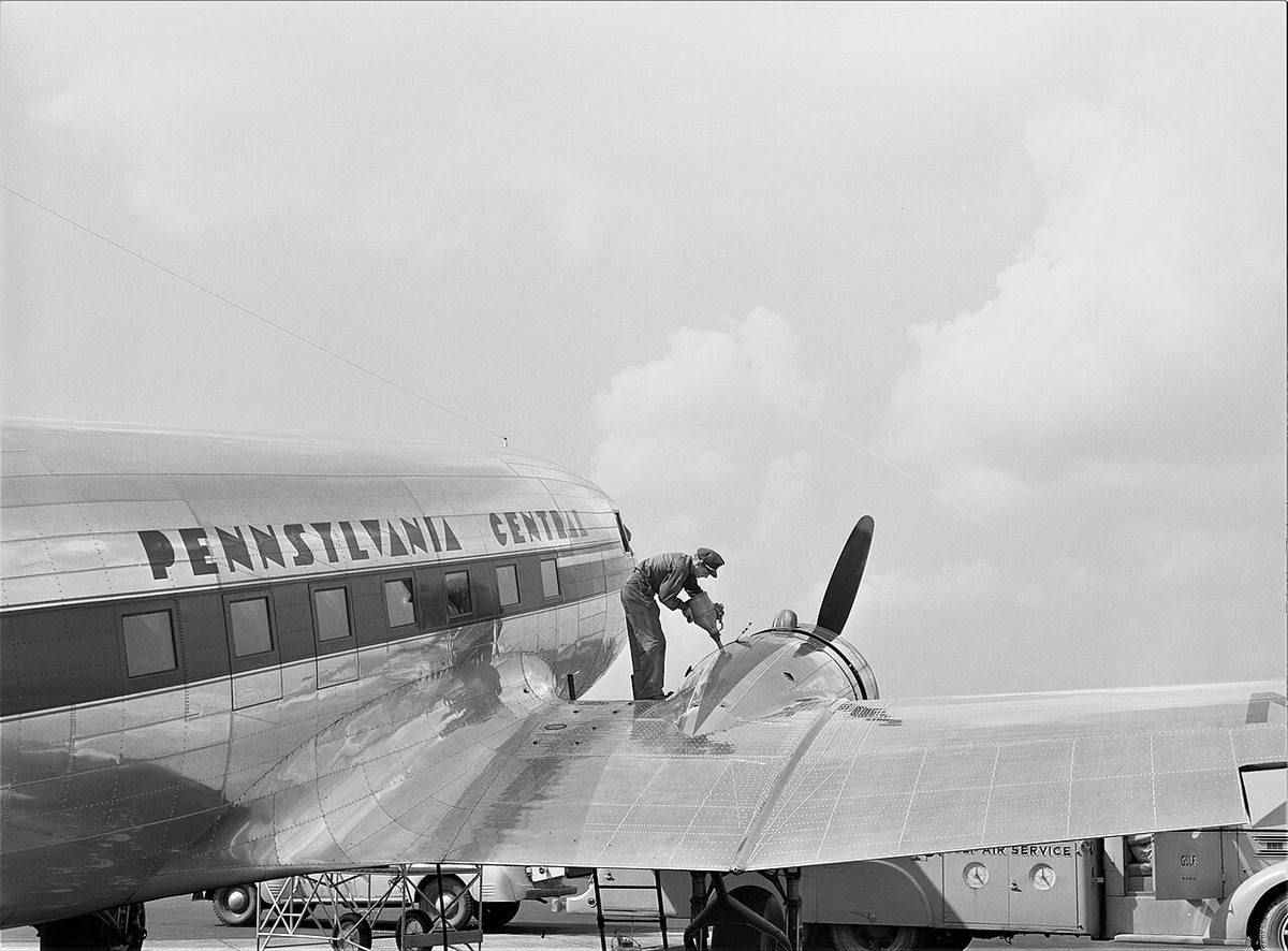 Oil being put into the engine of a 1940s airliner before a flight.