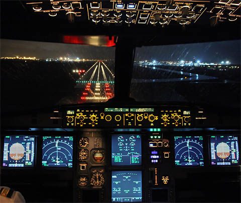 The flight deck of an Airbus A320 at night.