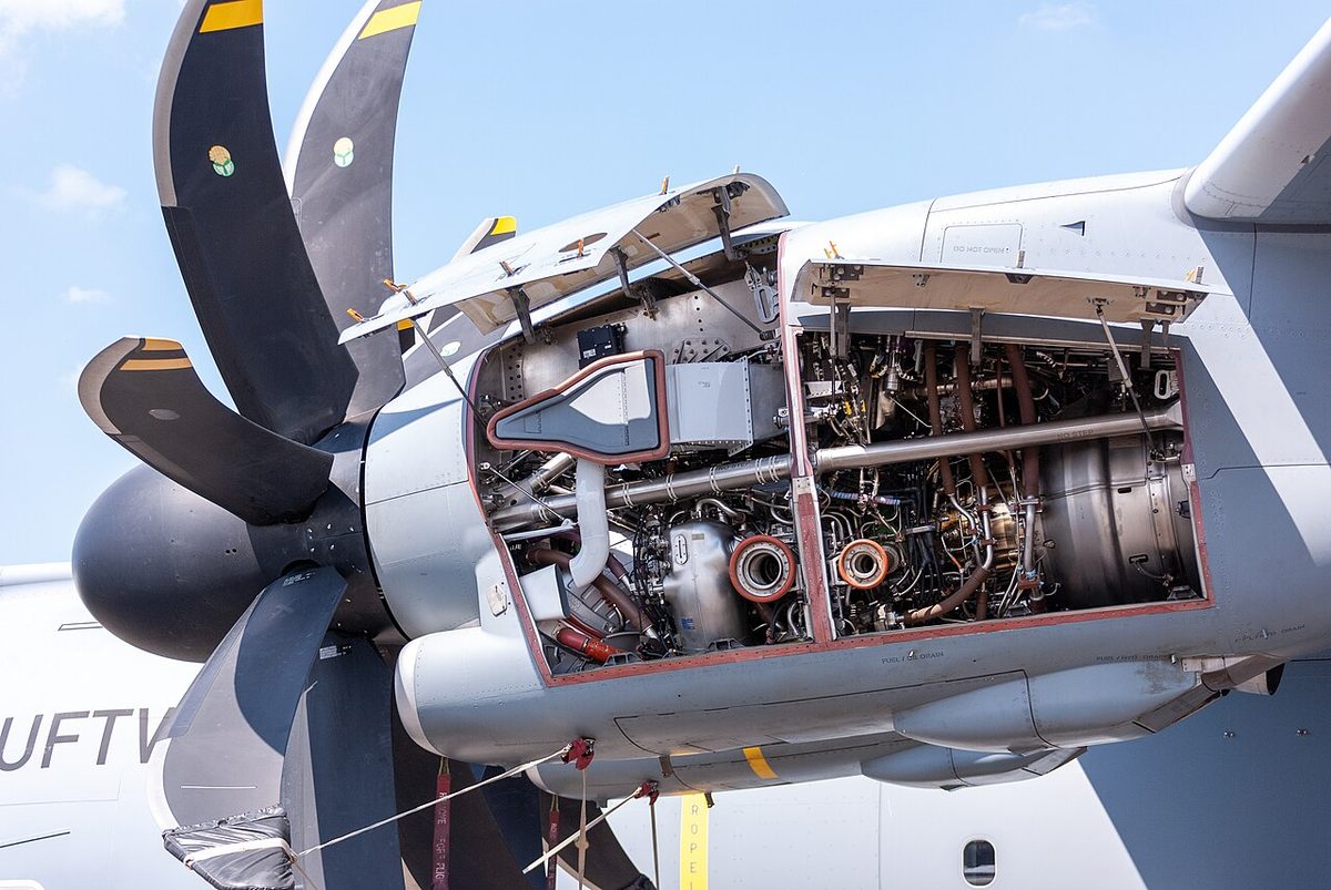 An Airbus A400M turboprop engine with its cowlings open, showing pipes, wiring and accessories mounted around the engine casing.