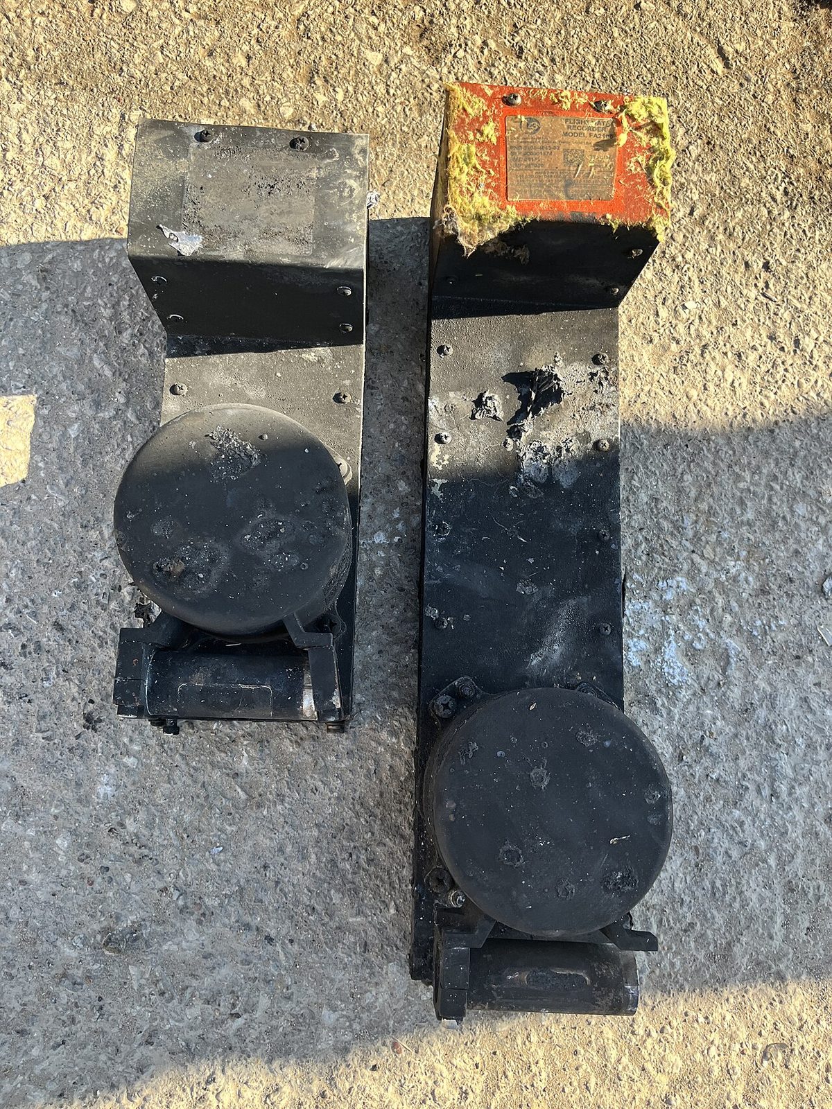 Two flight recorders after recovery from an accident site, a cockpit voice recorder on the left and a flight data recorder on the right.