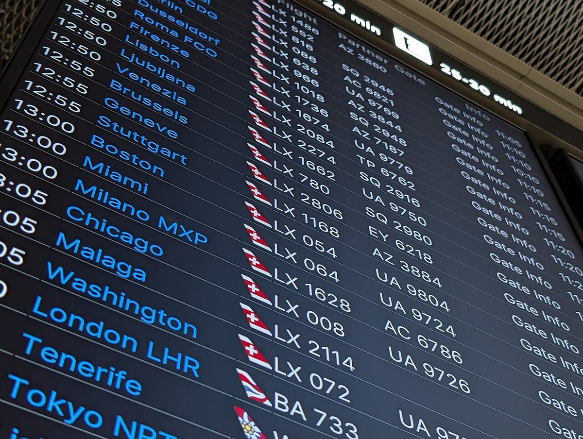 A flight departures board in the A gates of Zurich Airport, listing flights with their destinations and times.