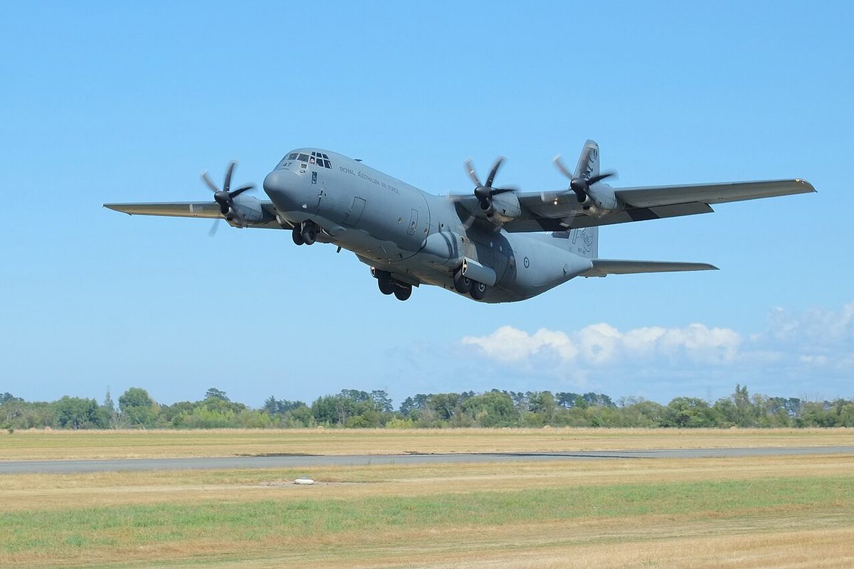 A Lockheed C-130J Hercules transport climbing away at low height during a go-around.