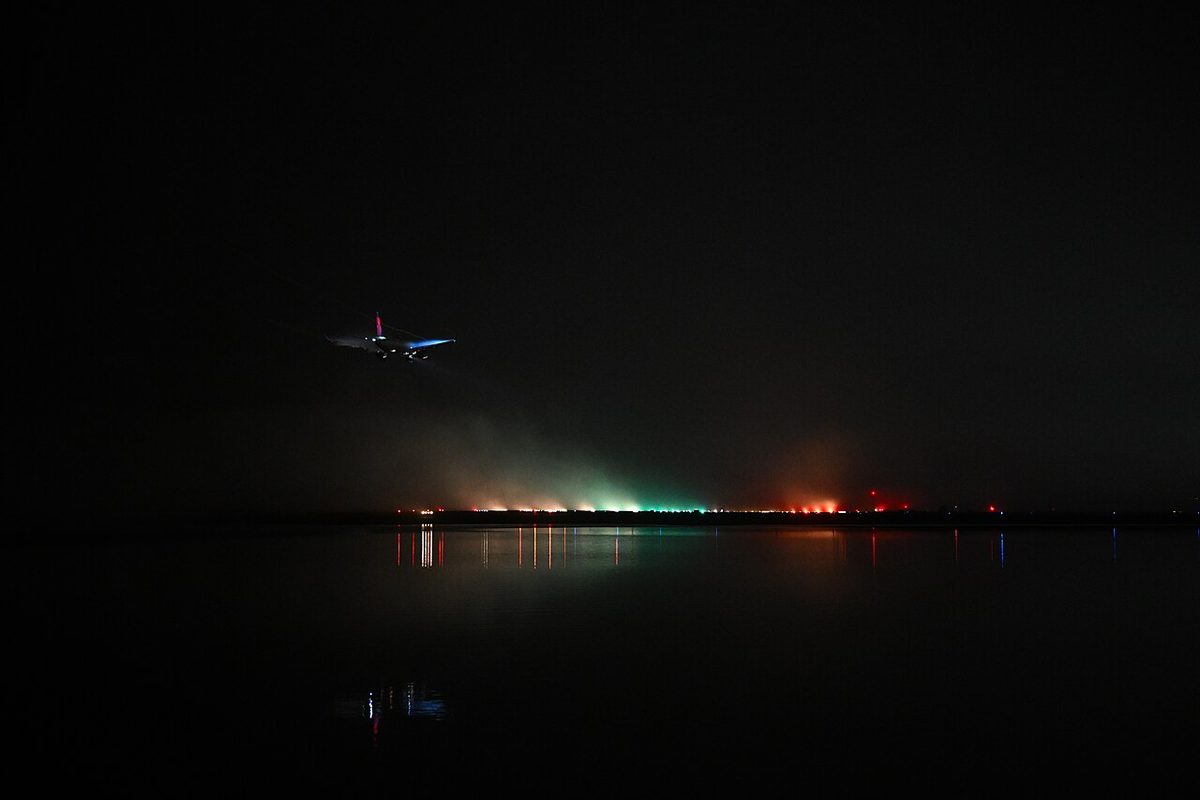 A Delta Air Lines Airbus A220 landing in fog, its surroundings grey and indistinct.