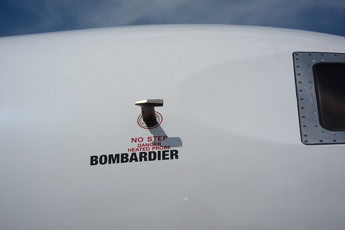 A small probe projecting into the airflow from the painted skin of a business jet.