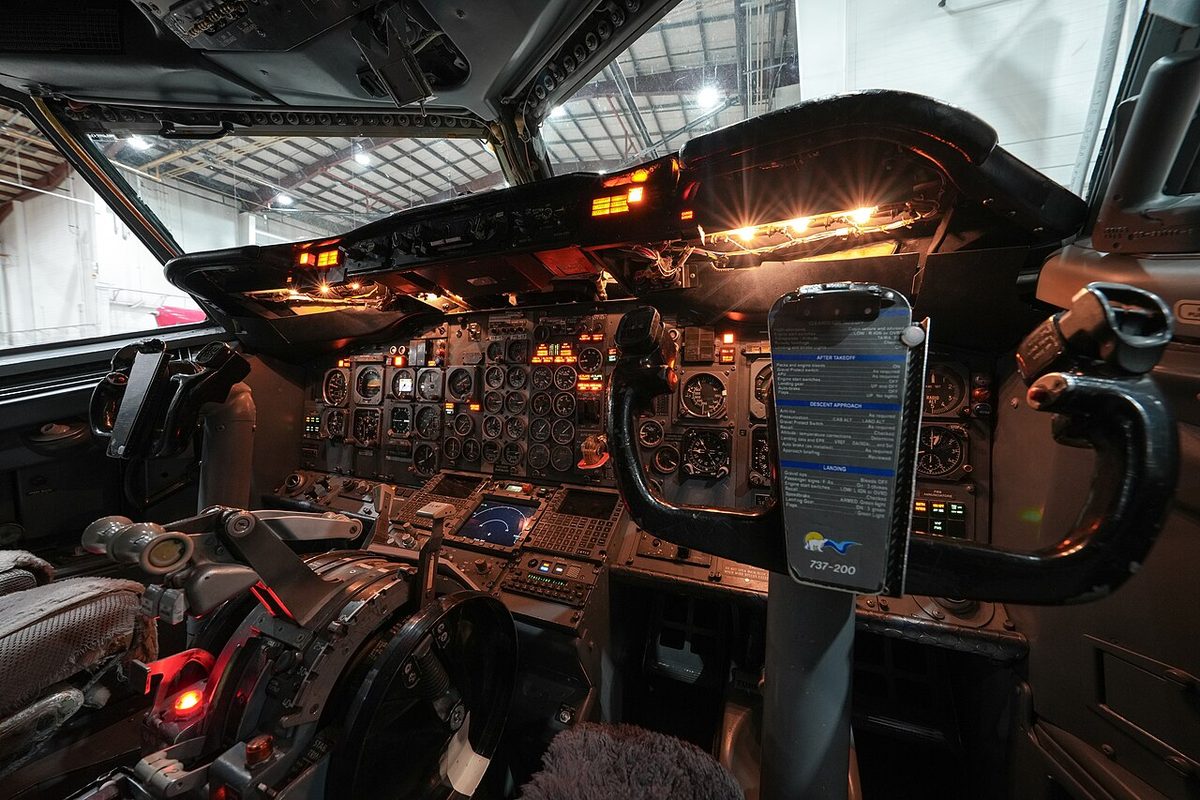 The flight deck of a Boeing 737-200, with round electromechanical flight and engine instruments on the main instrument panel.