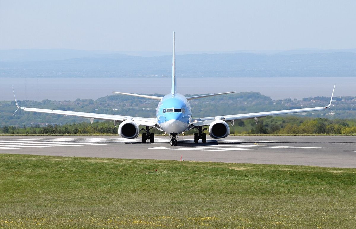 A twin-engined airliner seen head-on on a runway, its wings rising in a shallow V from the fuselage to the tips.