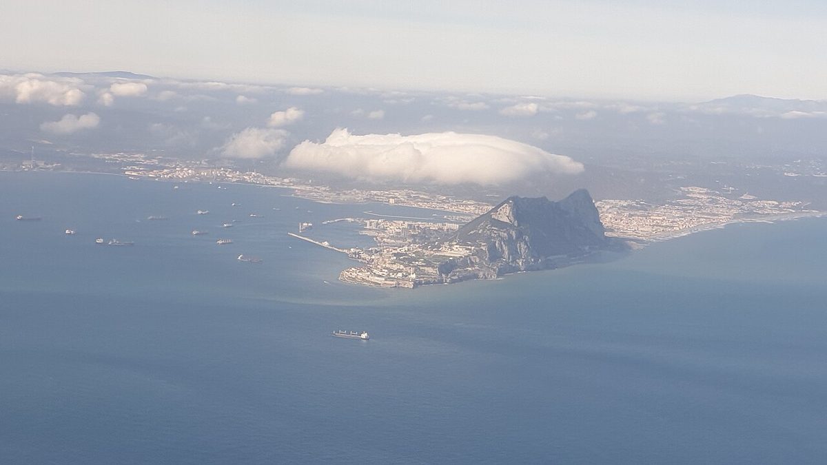 The Rock of Gibraltar with a long plume of cloud streaming from its summit.