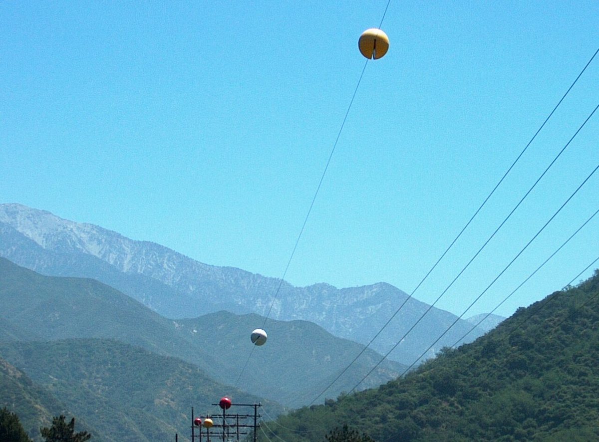 Large coloured balls fixed at intervals along overhead power cables.