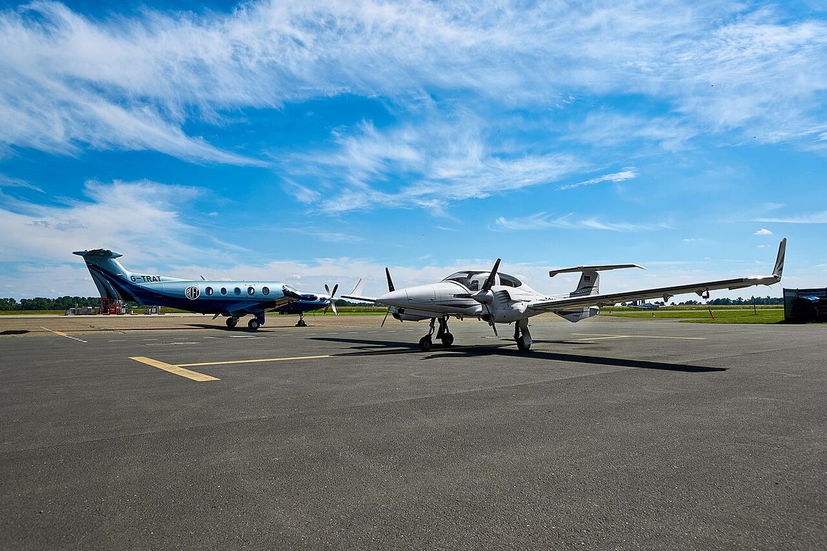 A Pilatus PC-12 single-engined turboprop and a Diamond DA42 light twin at an airfield.