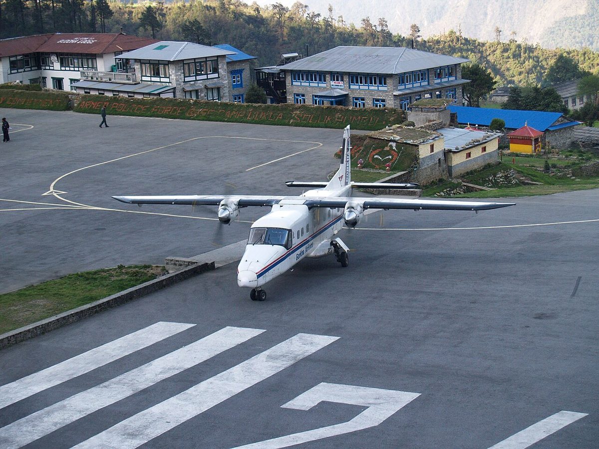 A Dornier 228 twin turboprop turning around on a runway.