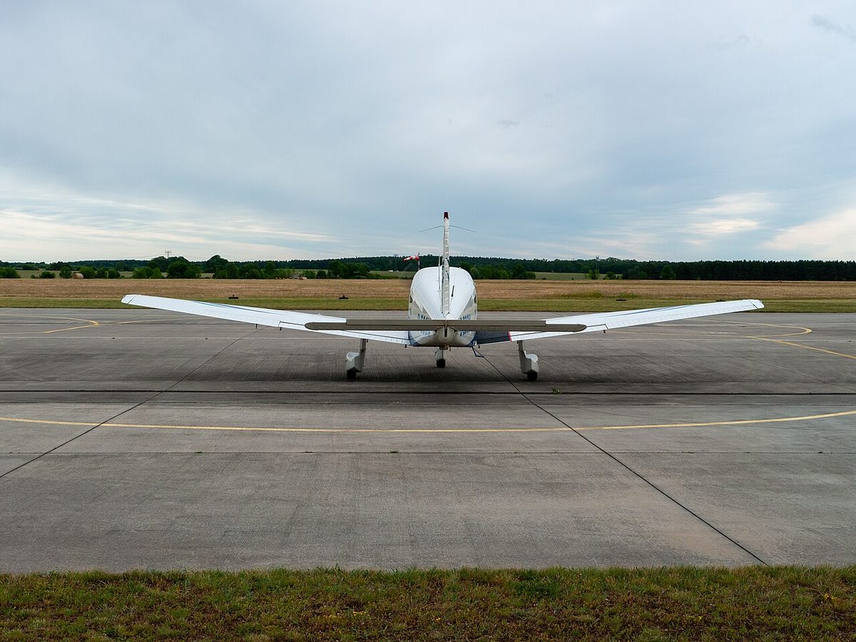 A Piper PA-28 Archer, a low-wing single-engine light aeroplane, seen head-on on an apron.