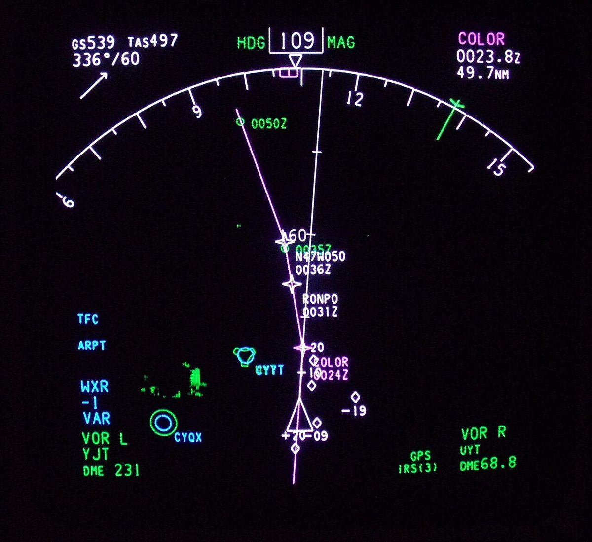 Dark screen with a white heading arc across the top, speed and wind figures at top left, and a route line with named waypoints running down the display.