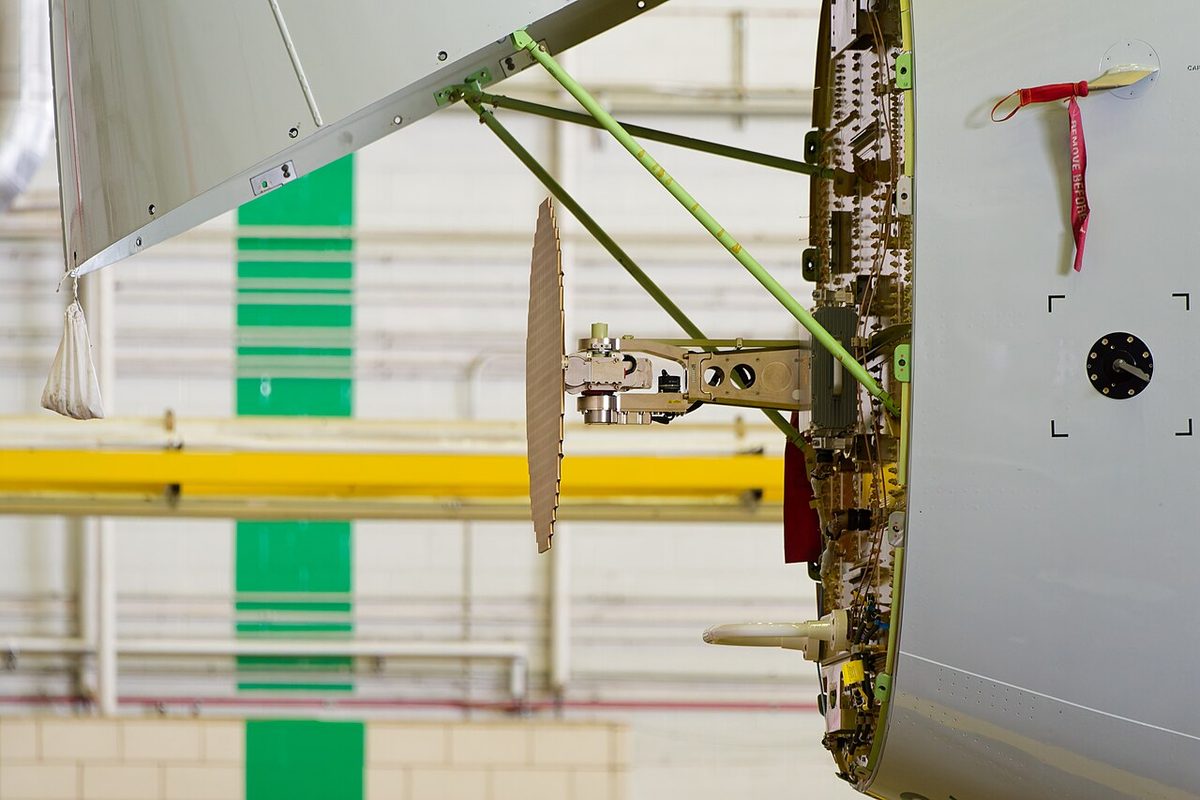 Airliner nose radome swung open to one side, exposing the weather radar antenna on its mount at the front of the fuselage.
