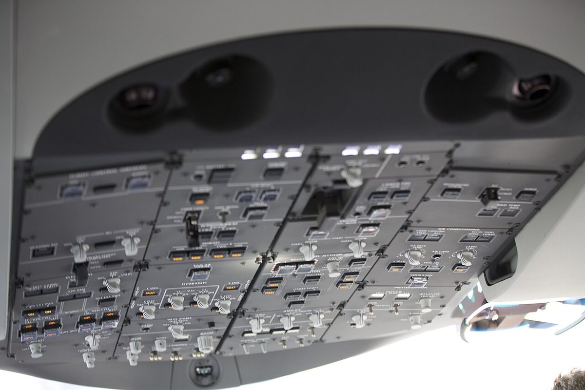 The overhead panel of a United Boeing 787, rows of switches and pushbuttons grouped by system.