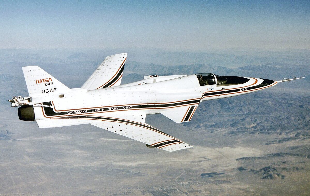 NASA's X-29 research aircraft in flight at a high angle of attack, with small cloth tufts attached in rows over its wing, rear fuselage and tail surfaces.