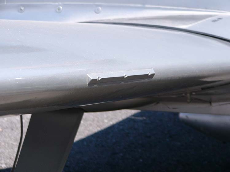 Close view of a small, sharp-edged stall strip fixed to the leading edge of an aircraft wing.