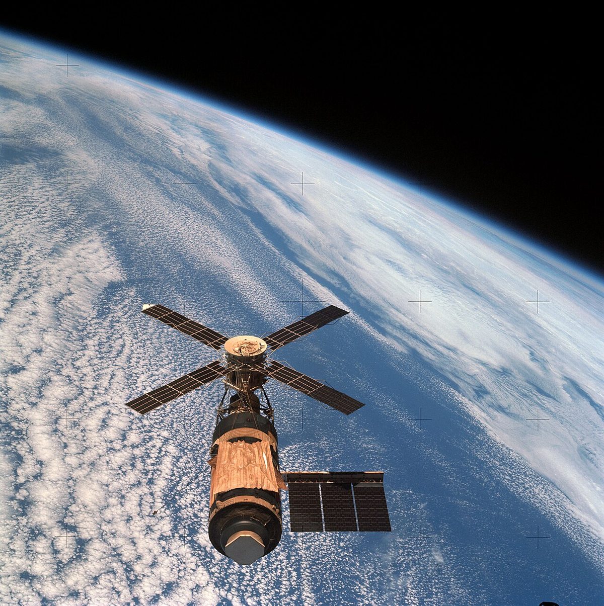 The curved edge of the Earth photographed from orbit, with a thin glowing band of atmosphere between the surface and the black of space.