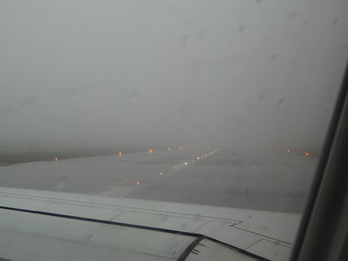 Runway lights shining through fog.