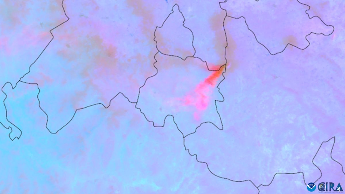 Satellite image of a volcanic ash cloud drifting away from its source over the sea.