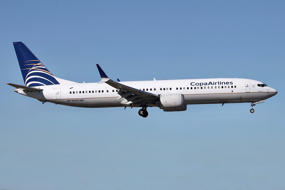 A Copa Airlines Boeing 737 MAX 9 in its white and blue livery in flight with its landing gear down.