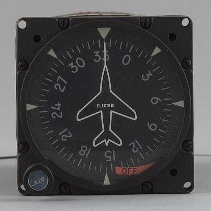 Square aircraft instrument: a compass card with heading numbers around a white aircraft outline, a knob at the bottom left and a red OFF flag at the bottom right.