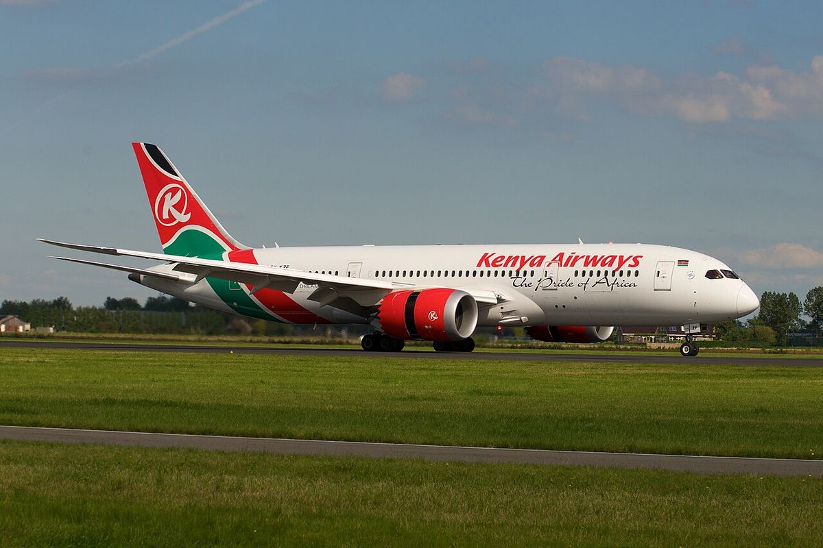 A Kenya Airways Boeing 787-8 in white livery with the red, green and black tail, rolling out on the runway.