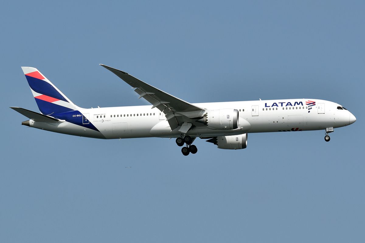 A LATAM Airlines Boeing 787-9 in flight with its landing gear down.