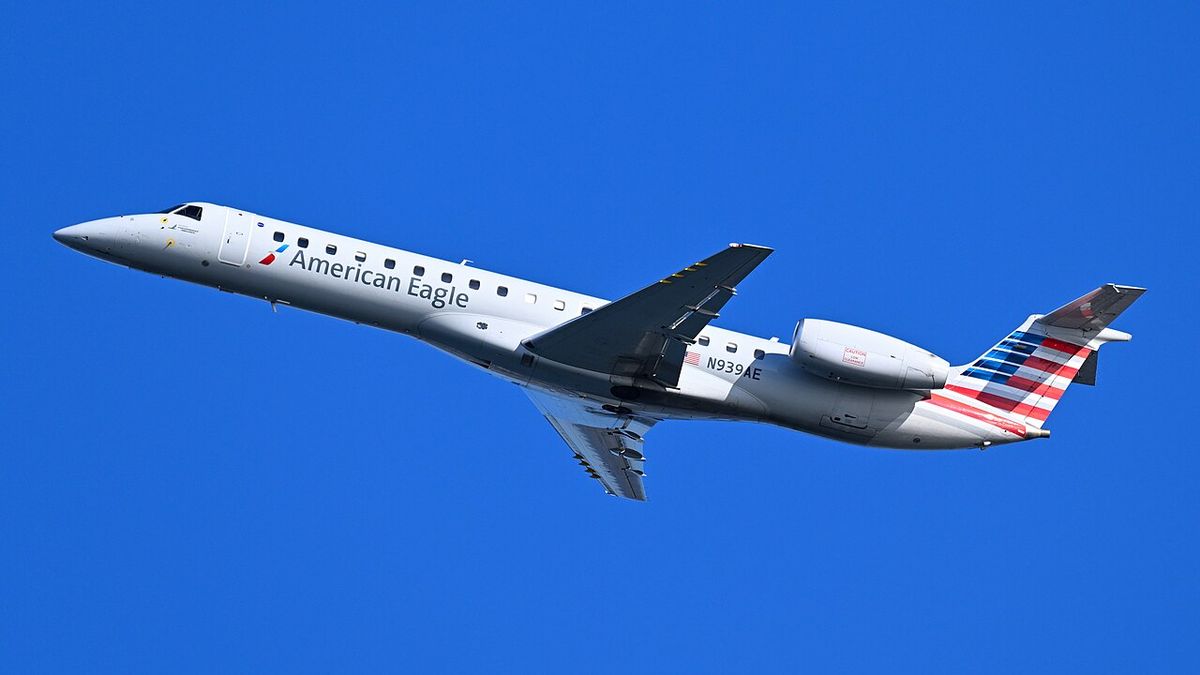 An American Eagle Embraer ERJ-145 flown by Piedmont Airlines climbing after takeoff against a blue sky.